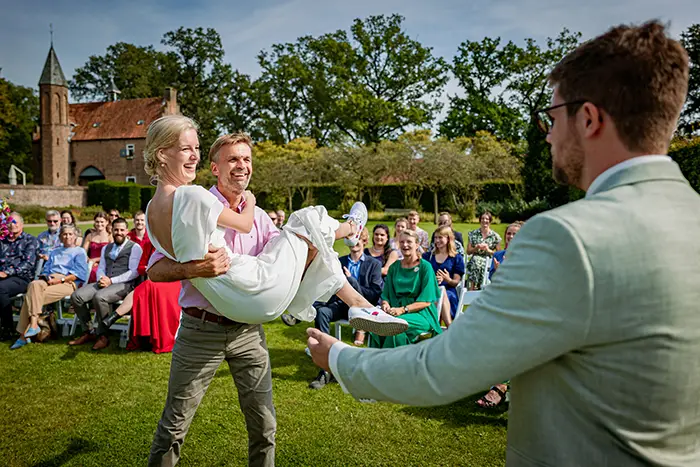 bruid wordt door vader op een unieke manier weggegeven trouwen momenten gezellig trouwfotografie